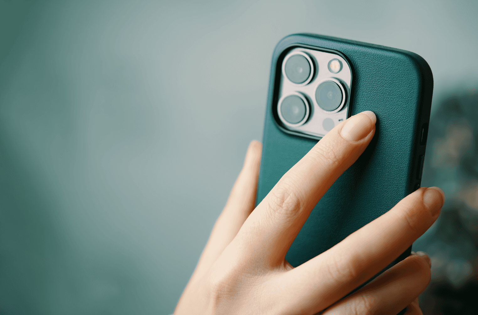Osoba trzymająca iphone, jako ilustracja do artykułu o tym jak zarabiać na aplikacji mobilnej i unikać prowizji App Store