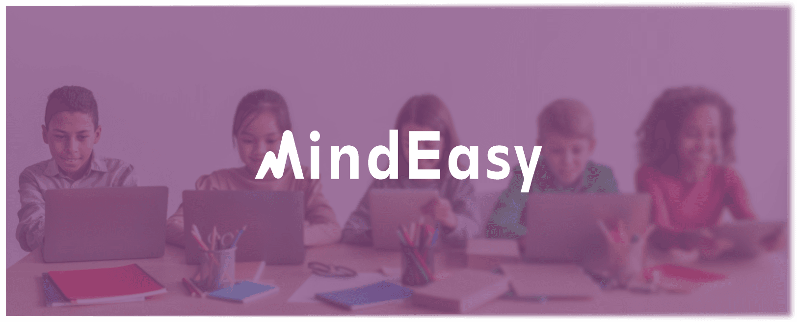 happy children sitting at a table with laptops open, illustrating the idea behind mindeasy, an edtech & neurotechnology startup case study by mobitouch